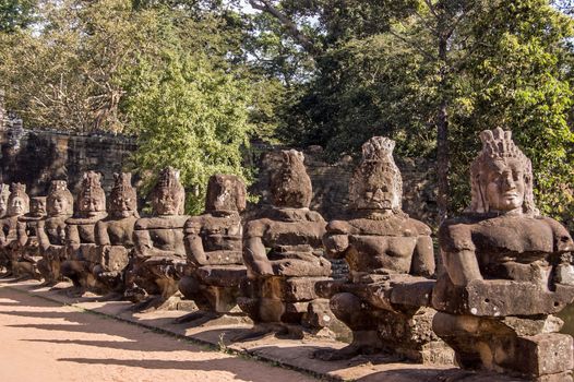 Asuras, or devils, pulling the Naga snake across the East gate entrance to Angkor Thom, Cambodia. The statues are part of a representation of the Churning of the Ocean of Milk - the Hindu creation.