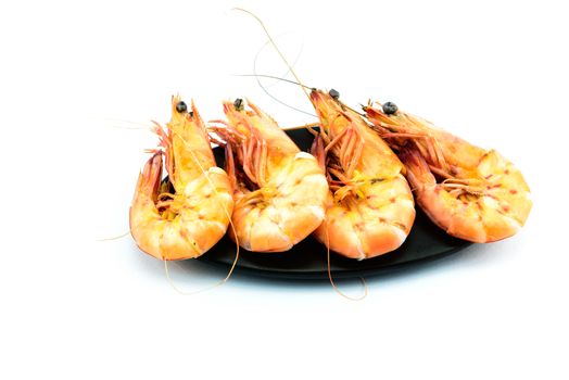 Boiled shrimp and black plate on white background	