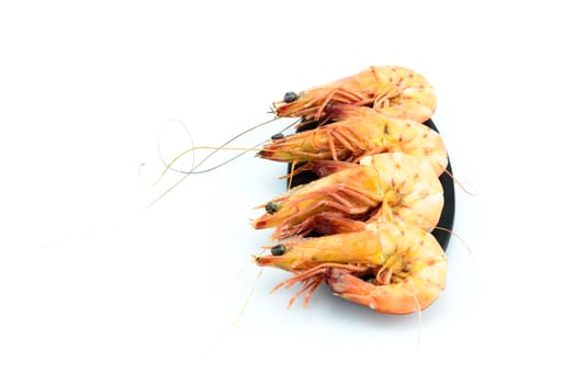 Boiled shrimp and black plate on white background	