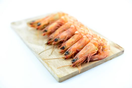 Boiled shrimp on wooden board on white background