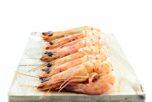 Boiled shrimp on wooden board on white background