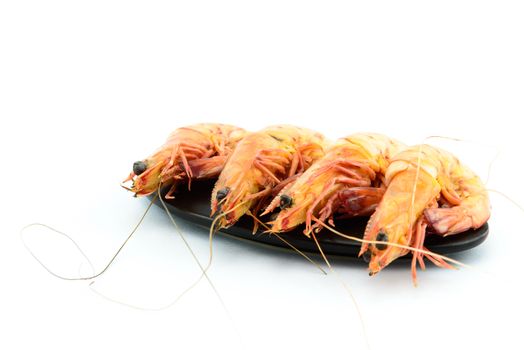 Boiled shrimp and black plate on white background