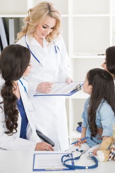 Young mother and girl in pediatrician office, doctor giving diagnosis and prescription