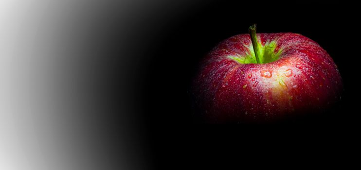 Close-up of Water droplet on glossy surface of freshness red apple on black background