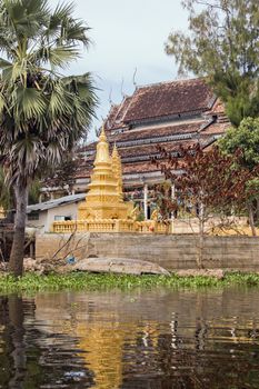 A golden pagoda, or stupa, beside a Buddhist temple in the floating village of Kompong Phluk, Tonle Sap lake, Cambodia.