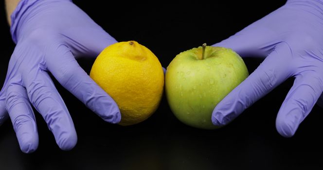 Doctor's hands with apple and lemon on black background. Concept healthy life without pills, drugs. To be healthy from fruit vitamins