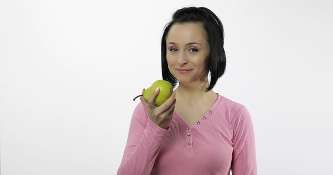 Young beautiful woman with big, fresh, juicy, green pear. Healthy nutrition