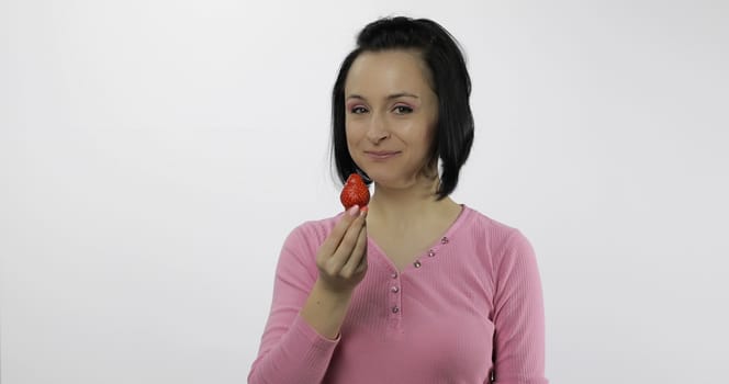 Young beautiful woman with fresh and juicy strawberry. Healthy nutrition