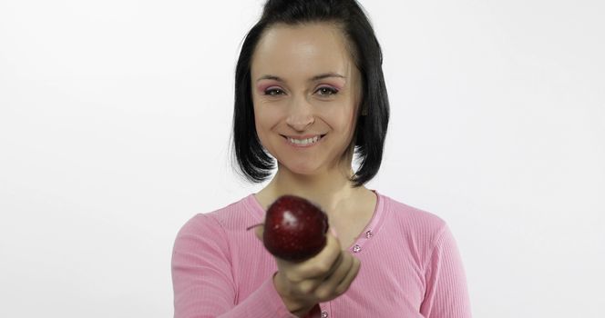 Young beautiful with red apple offer bite to viewer. Healthy nutrition.