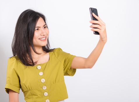 Portrait Asian beautiful happy young woman standing smile, holding mobile phone her taking selfie on white background, with copy space