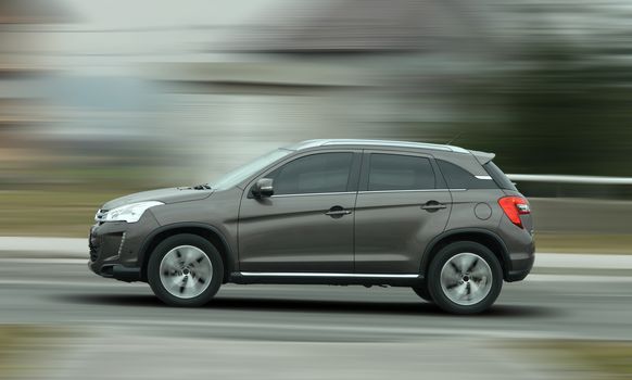 A panning shot of a speeding SUV