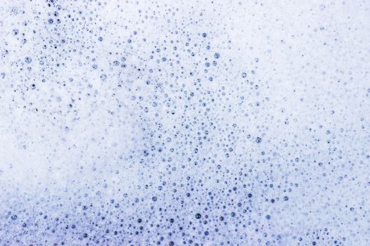 White bubble of detergent in blue container for background. Abstract texture.