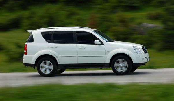 A panning shot of a speeding SUV
