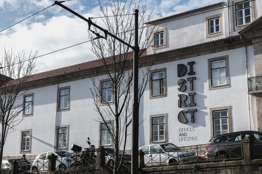 Porto, Portugal - November 30, 2018: Storefront and architectural detail of District - Offices and Lifestyle, a co working space in the historic city center on a winter day