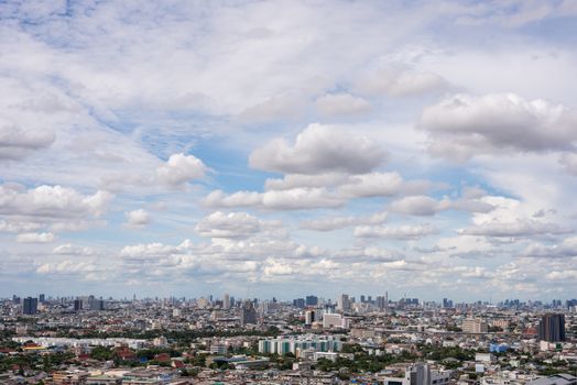 The Bangkok cityscape from skyscraper view with clouds and blue sky.