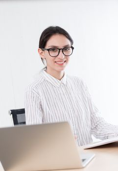 A businesswoman wearing glasses working with smiling and happiness at the office.