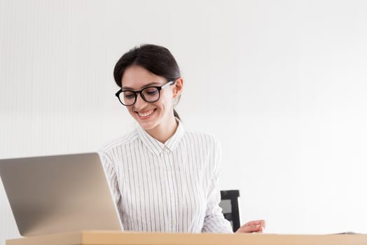 A businesswoman wearing glasses working with smiling and happiness at the office.