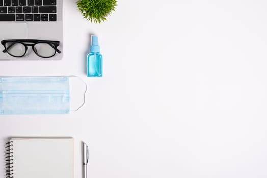 The equipment to protect COVID-19, blue mask and hand cleaner gel for preparing to work from home Isolated on white background concept.