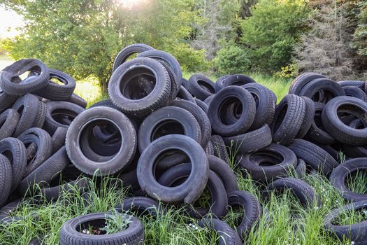 Damaged and worn old black tires on a stack. Tire tread problems. Solutions concept.