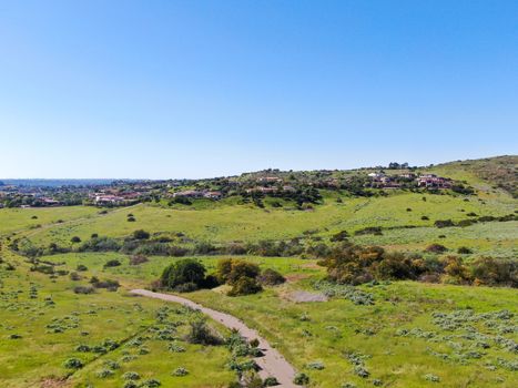 Aerial view of green valley with big luxury villa on the background in a private community, San Diego, California.