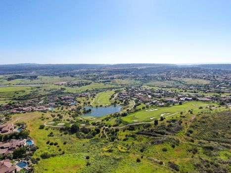 Aerial view of green valley with big luxury villa on the background in a private community, San Diego, California.