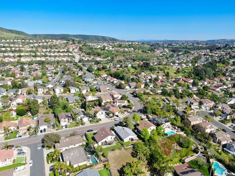 Aerial view of upper middle class neighborhood with residential subdivision mansion and swimming pool during with blue sky in San Diego, California, USA.