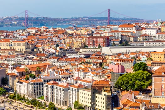 View to downtown of Lisbon with miltiple streets and houses and bridge of 25 of April in a background, Portugal