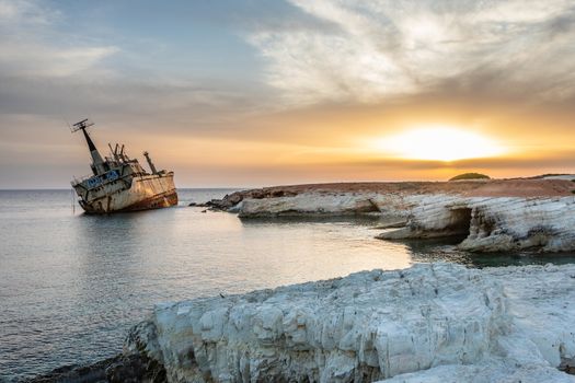 Abandoned rusty ship stranded ashore  in the sunset rays at Peyia village, Paphos