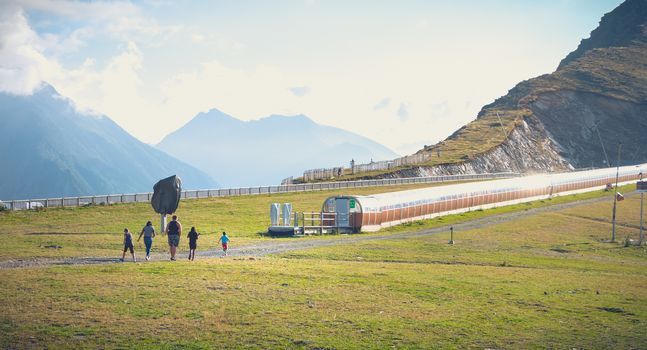 Saint Lary Soulan, France - August 20, 2018: family who walks on the ski slopes of a resort without snow in summer