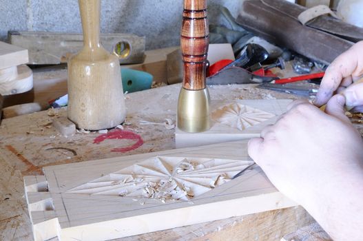 Working with carpenter tools to carve wood.