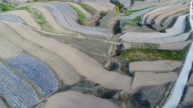 Aerial view of terraced farm field mass production during summer dry season in Tianshui, Gansu Province, China.