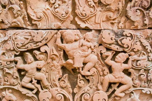 Ancient Khmer bas relief carving showing Sita being abducted by Ravan. Ram and Laxman look on helpless. Part of the Ramayana Hindu legend. Banteay Srei temple, Angkor, Cambodia.