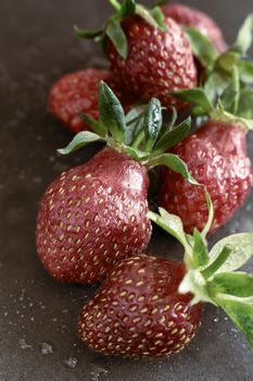 On a black background ripe red strawberry berries close-up.