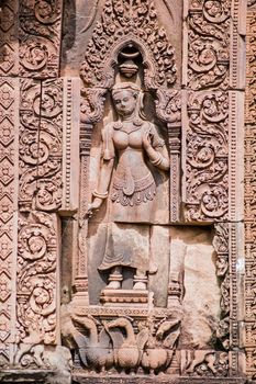 Ancient Khmer bas relief carving of a devata goddess with a gaggle of geese on a Prasat at Banteay Srei Temple, Angkor, Cambodia. Sandstone carving over 1000 years old.
