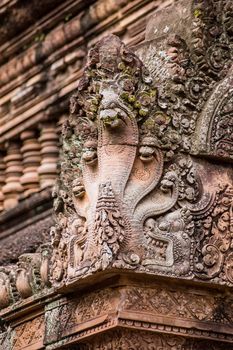 Ornate carving of a Naga, Hindu snake god, on the corner of a prasat at Banteay Srei Temple, Angkor, Cambodia.