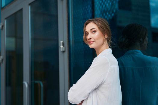 Businesswoman successful woman business person standing arms crossed outdoor corporate building exterior Pensive elegance caucasian confidence professional business woman middle age female leader