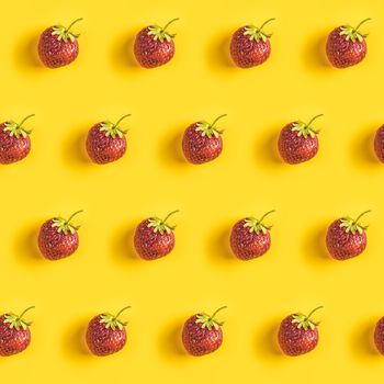Strawberry seamless pattern, strawberries on yellow colored background, top view, creative minimalist flat lay, summer pattern