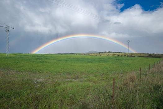 Full rainbow over farm fields