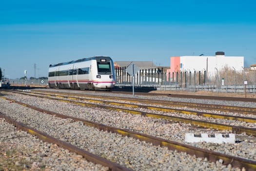 Passenger train passing through the highway approaching a station