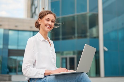 Businesswoman successful woman business person outdoor corporate building exterior with laptop Pensive elegance cute caucasian professional business woman middle age ecommerce deal Online banking