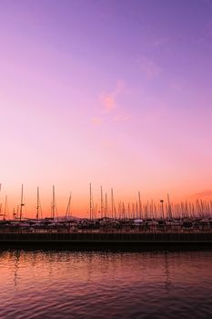 Yachts and boats in the harbor on Mediterranean sea coast at sunset, travel and leisure scene