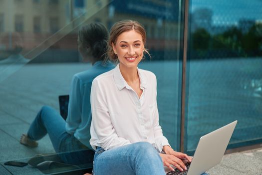 Businesswoman laptop successful woman business person outdoor corporate building exterior Pensive elegance caucasian professional business woman middle age ecommerce deal Online banking Sitting ground