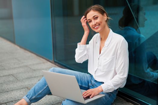 Businesswoman laptop successful woman business person outdoor corporate building exterior Pensive elegance caucasian professional business woman middle age ecommerce deal Online banking Sitting ground