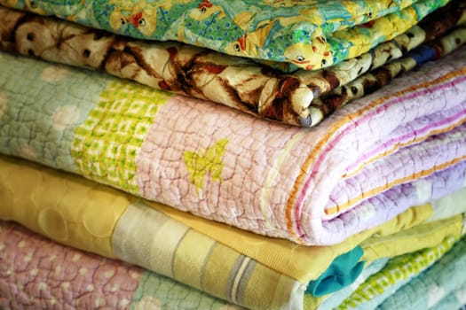 Stock of colorful old washed blankets folded after laundry.