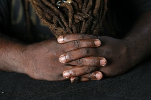 Close up of hands of African-American man holding dreadlocks