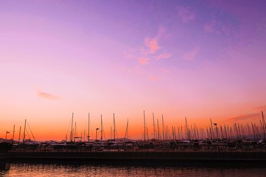 Yachts and boats in the harbor on Mediterranean sea coast at sunset, travel and leisure scene