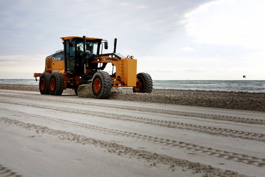 Gulf of Mexico, Padre Island, Texas. Grader adjusting send level on the beach. Beach Maintenance.