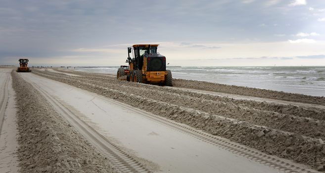 Gulf of Mexico, Padre Island, Texas. Grader adjusting send level on the beach. Beach Maintenance.