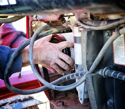 Mechanic installing new air filter in large tractor