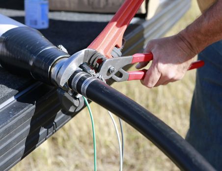 Close up of plumbers hands mounting new submersible water pump